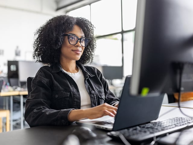 IT expert at work on the computer, symbolizes USU Professional Services and training for IT monitoring.