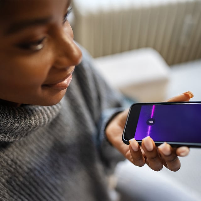 Woman uses voice control on smartphone – using AI efficiently.