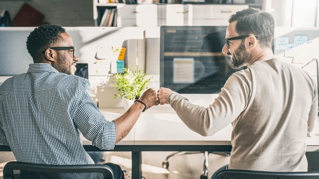 Two men fist bumping